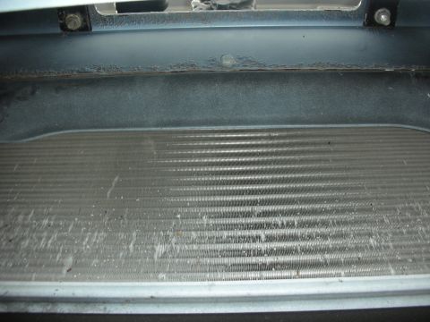 2004 Ford Crown Victoria - Close-up view of a radiator grille, showing accumulated debris and damage to the fins.