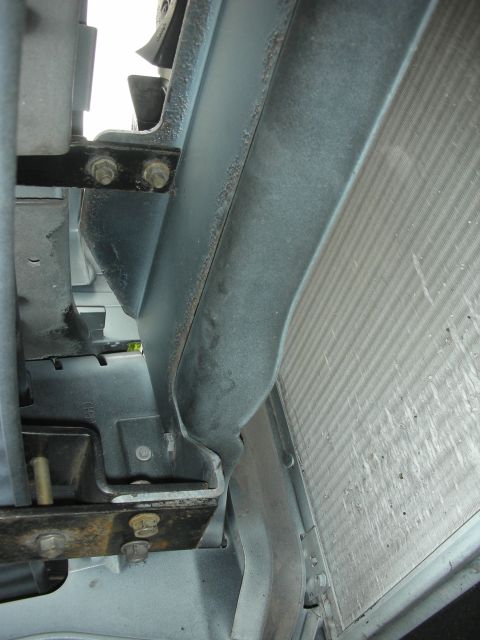 2004 Ford Crown Victoria - Radiator and mounting bracketry, likely from the front of a vehicle.