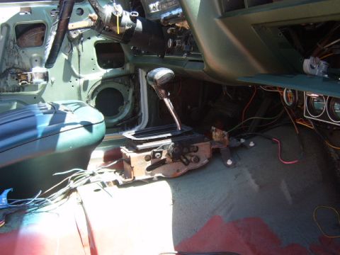 1973 Ford Ranchero - The interior of a vehicle is shown with parts disassembled, revealing wiring and the central console area.