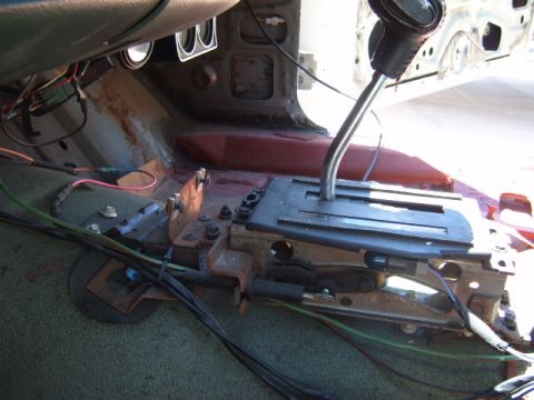 1973 Ford Ranchero - The interior of a vehicle shows an automatic transmission shifter and floor console with visible wiring and signs of wear.
