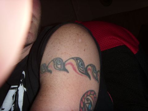 1978 Ford Bronco - A person's arm displays a tattoo band with eye-like designs and another circular tattoo.