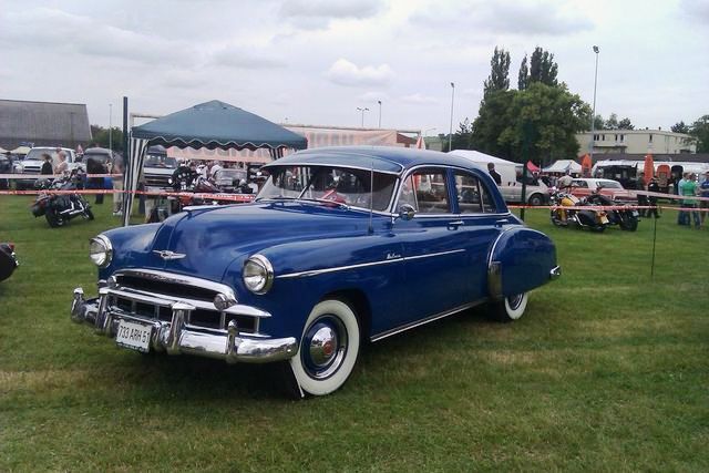 Blue sedan with whitewall tires and chrome grille. License plate reads 733 ARH 6