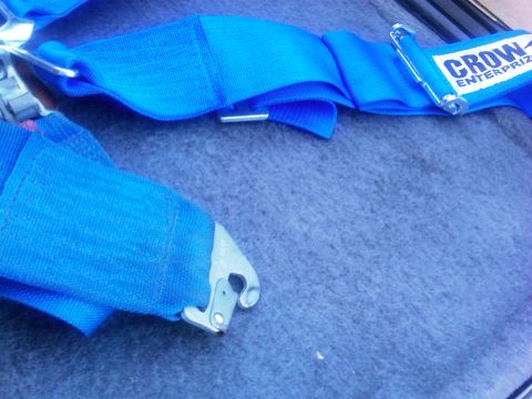 1986 Ford Bronco - Close-up of a blue racing harness with a metal buckle and "Crow Enterprises" label.
