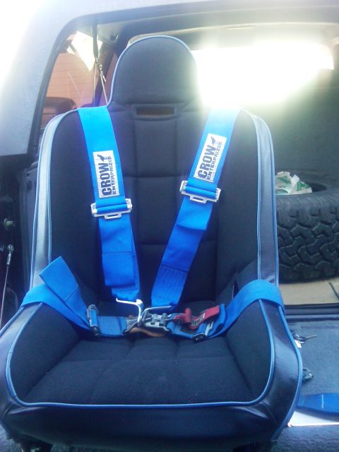 1986 Ford Bronco - A racing seat with blue Crow Enterprises harness is installed in a vehicle's interior.