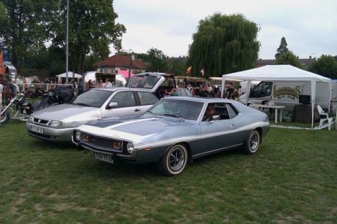 1991 Ford Crown Victoria - A classic blue and silver American muscle car with a white stripe is displayed at an outdoor event.