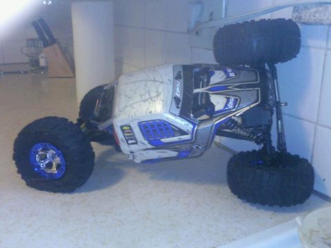 1996 Ford Bronco - A remote control car with blue accents and large tires is shown from a three-quarter front angle.