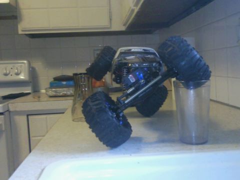 1996 Ford Bronco - A remote control rock crawler truck is positioned on a kitchen counter, with one of its large tires resting inside a drinking glass.