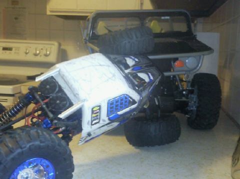 1996 Ford Bronco - Two RC rock crawlers are positioned on a kitchen counter near a stove.