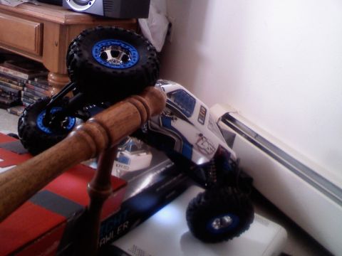 1996 Ford Bronco - A white and blue remote control rock crawler toy is positioned on a surface, with its large tires visible.