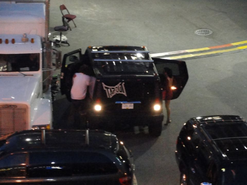 Black SUV with 'Tapout' logo on the rear, doors open, people near it