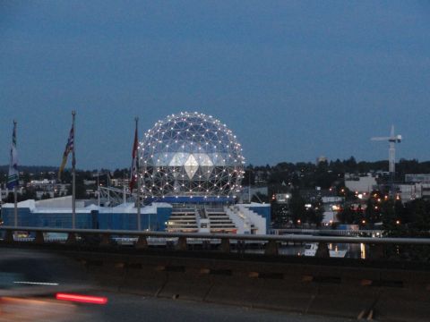 1996 Ford Bronco - A wide shot captures a geodesic dome stadium illuminated at dusk, with the city skyline and a construction crane visible in the background.