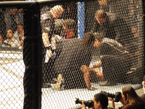 1996 Ford Bronco - MMA event with fighters, referees, and photographers capturing the action inside and outside the cage.