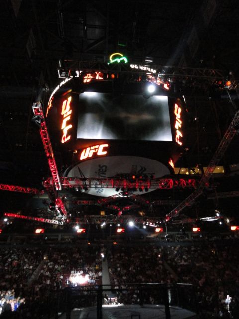 1996 Ford Bronco - View of a UFC event inside a stadium, showing the octagon and a large overhead screen.