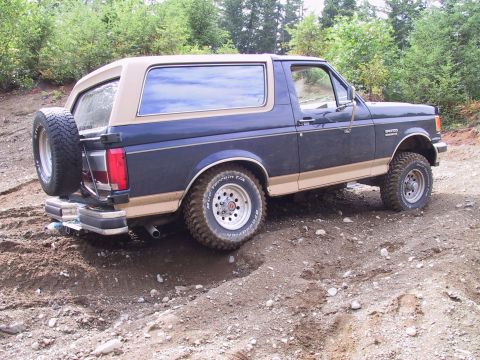1991 Ford Bronco - The Ford Bronco navigates a rough, muddy terrain, its off-road capabilities.