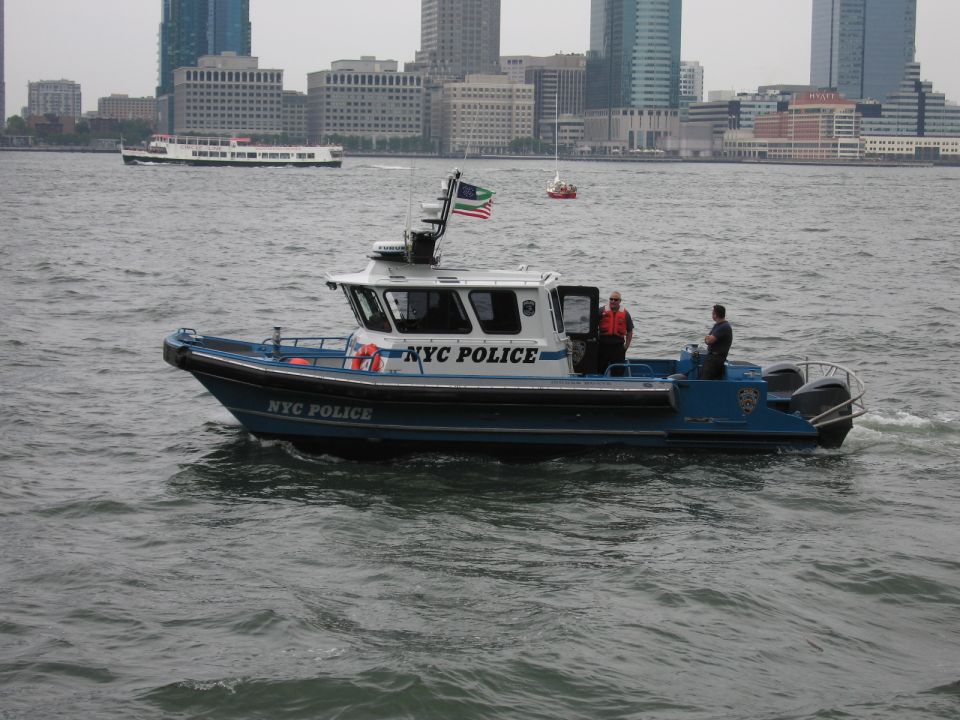 NYC Police patrol boat underway on a harbor with city skyline behind