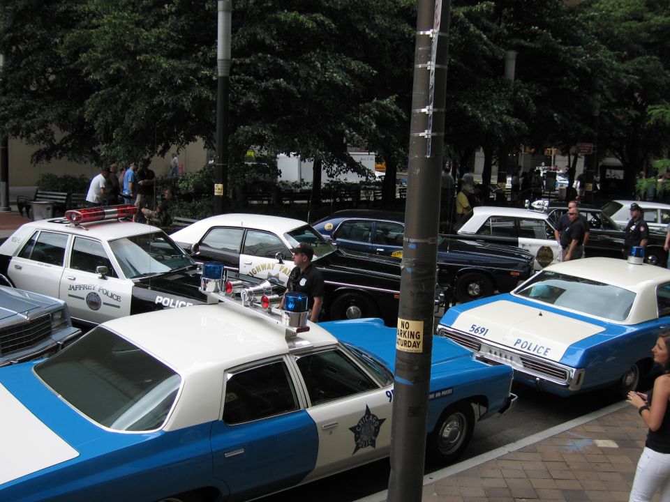 Blue and white Chicago-style police cars parked around a light pole