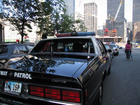 1991 Ford LTD Crown Victoria - Rear-quarter view of a black Chevrolet Caprice Highway Patrol sedan with Wyoming plate and roof lights parked along a street near construct…