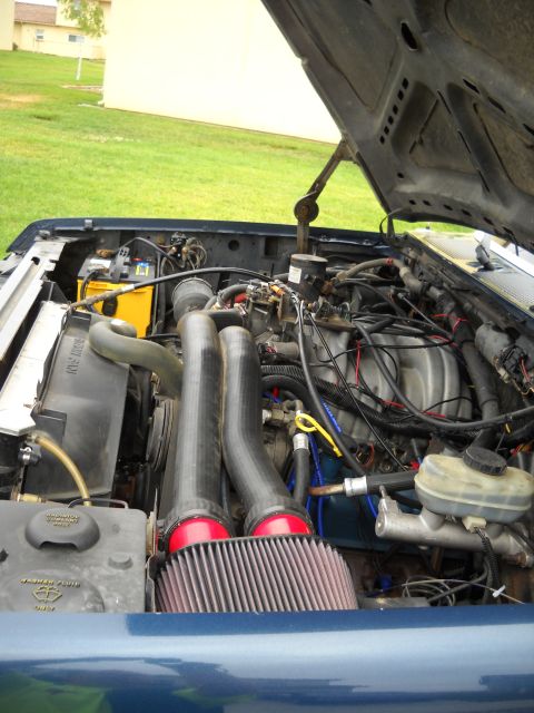 1986 Ford Bronco - The engine bay of a vehicle, showing various components and aftermarket modifications.