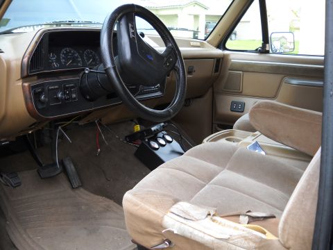 1986 Ford Bronco - The interior of a 1987 Ford F-Series truck features tan upholstery and a dashboard with visible gauges.