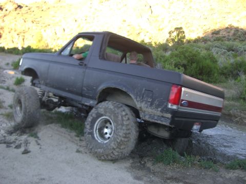 1987 Ford Bronco - This lifted 1987 Ford Bronco navigates a muddy off-road trail.