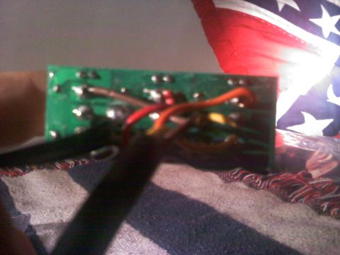 1996 Ford Bronco - A close-up view of a green circuit board with several wires connected.