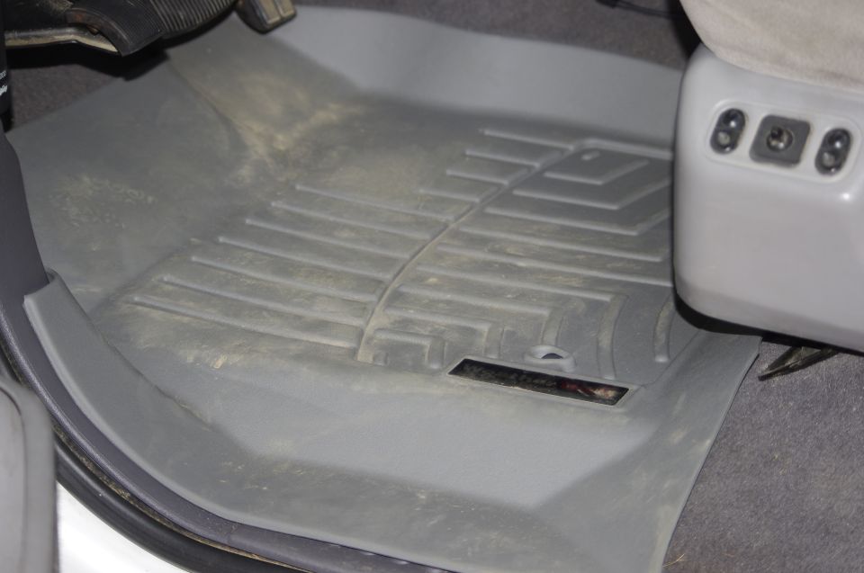 Gray WeatherTech floor mats in a vehicle interior, showing seat adjustment controls