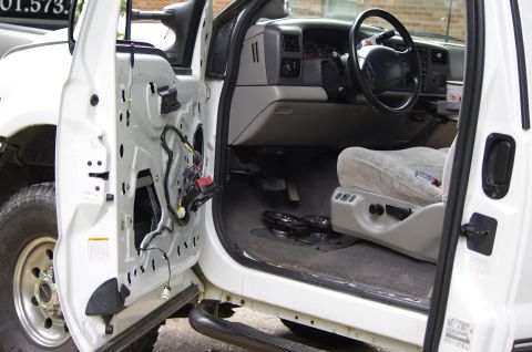 1999 Ford F-250 - Interior view of a Ford Super Duty truck with the driver's door panel removed, revealing wiring.