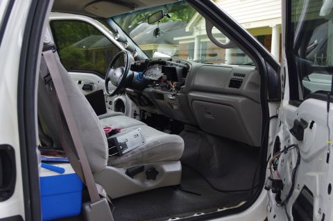 1999 Ford F-250 - The interior of a 1999 Ford F-250 shows a disassembled dashboard and gray upholstery.