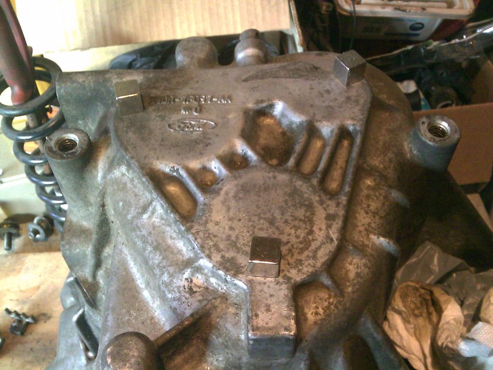 Used cast-aluminum Ford part with cast part number and Ford oval on a workbench