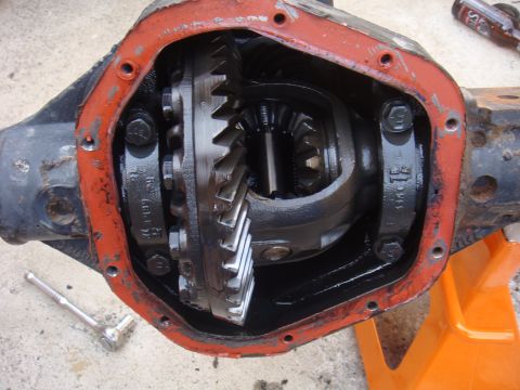1992 Ford Bronco - Close-up of an open differential housing with gears visible, a ratchet lies on the concrete floor.