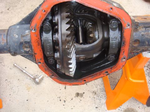 1992 Ford Bronco - Close-up view of differential gears, showing the internal components and an orange gasket seal. A socket wrench lies nearby.