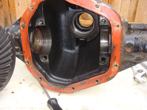 1992 Ford Bronco - Close-up view of a differential housing, showing the internal gears and bearing surfaces, with an orange gasket seal.