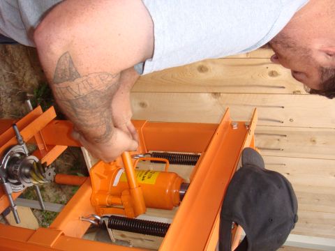 1992 Ford Bronco - A person operates an orange hydraulic jack near axle components, with a "SUPERMOTORS" watermark visible.