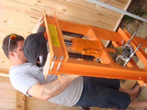 1992 Ford Bronco - A man holds an orange hydraulic press, which appears to be a component rather than a complete vehicle.