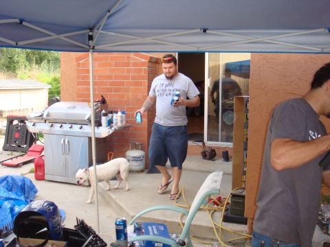 1992 Ford Bronco - A casual backyard gathering with a grill, a dog, and people enjoying drinks.