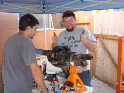 1992 Ford Bronco - Two men work on a differential assembly, with one giving a thumbs-up.