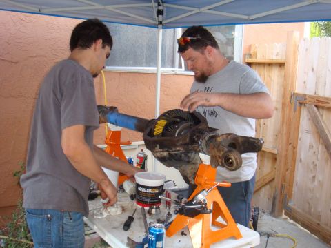 1992 Ford Bronco - Two men work on a vehicle differential assembly outdoors.