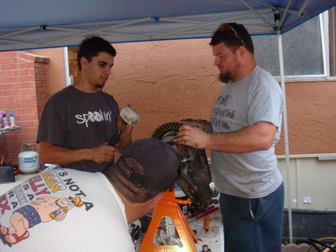 1992 Ford Bronco - Three men are gathered around a workbench, focused on assembling a vehicle differential.