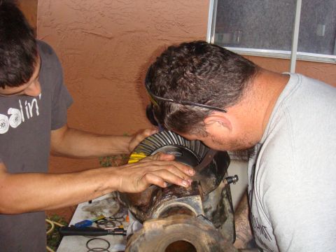 1992 Ford Bronco - Differential gear assembly being inspected by two mechanics.