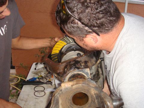 1992 Ford Bronco - A close-up view of a differential gear assembly being inspected by two individuals.