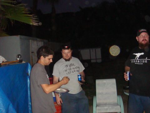 1992 Ford Bronco - A group of men are gathered outdoors at night, with one man holding a plate and another holding a can of beer.