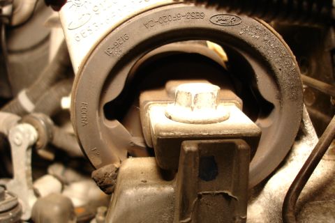 2006 Ford Fusion - Close-up of a Ford rubber engine/transmission mount marked with part number '6E53-6F020-CA' and 'ECCRA', showing the bolted metal bracket p…