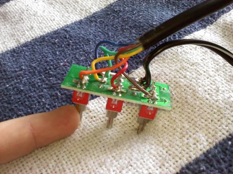 1996 Ford Bronco - Close-up of a circuit board with multiple red connectors and various colored wires attached.