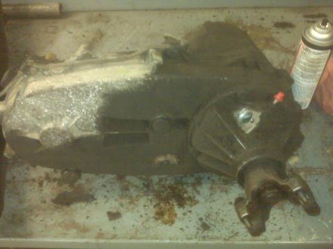 1994 Ford F-250 - A transfer case sits on a workbench, possibly awaiting repair or installation.