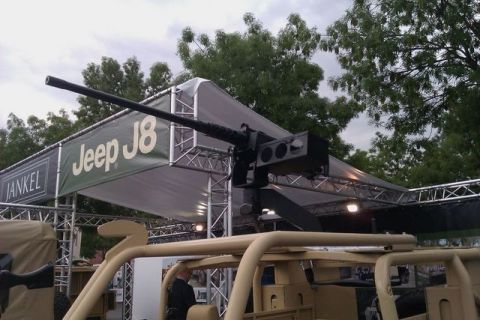 1991 Ford Crown Victoria - A Jeep J8 is displayed with a heavy weapon mounted on top, under a tent structure.