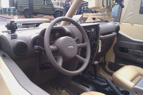1991 Ford Crown Victoria - The interior of a Jeep is visible, with a tan dashboard and seats, and a weapon system mounted behind the driver.