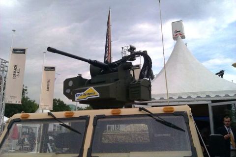 1991 Ford Crown Victoria - A tan military vehicle is equipped with a complex weapon system, with banners and a tent visible in the background.