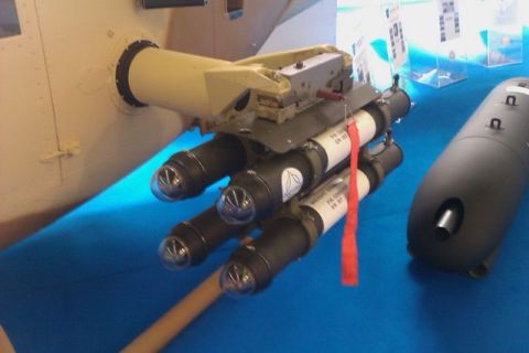 1991 Ford Crown Victoria - A display shows a missile launcher and a bomb, likely at an airshow or exhibition.