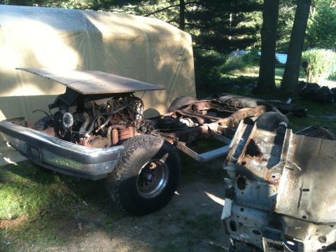 1988 Ford Bronco - Truck chassis and engine are disassembled and exposed in an outdoor setting.