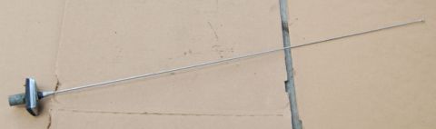 1988 Ford Bronco - A car antenna is shown lying on a flat, cardboard surface.